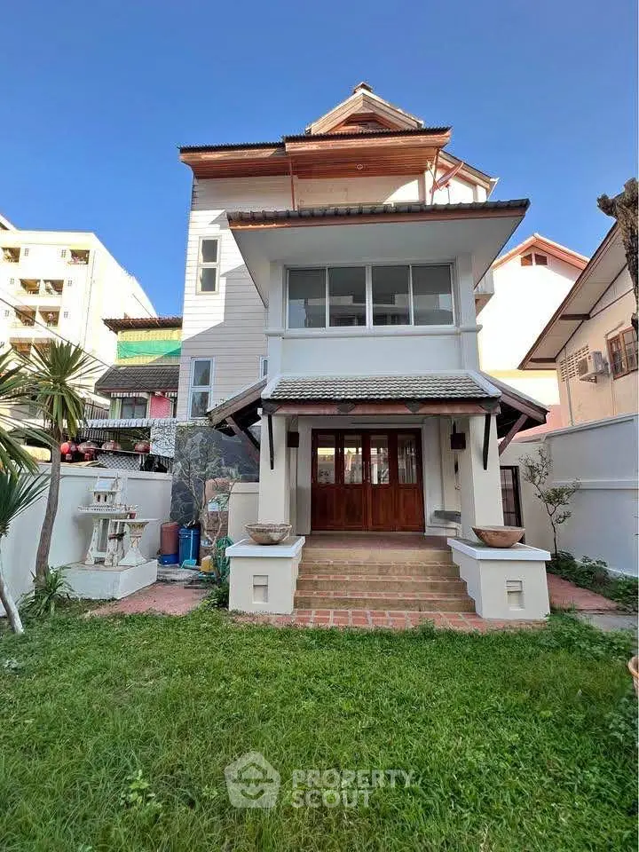 Charming multi-story house with lush garden and traditional architectural design.