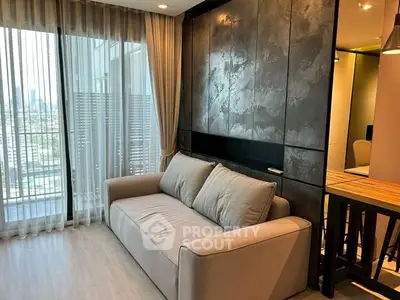 Modern living room with stylish sofa and floor-to-ceiling windows offering city views.