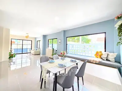 Spacious modern living room with dining area and large windows offering natural light.