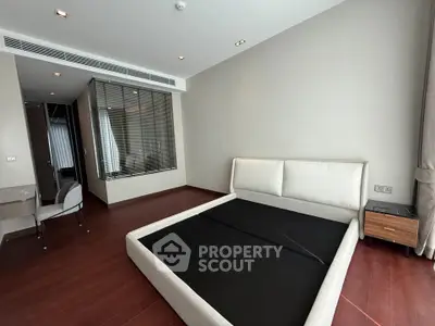 Spacious modern bedroom with elegant hardwood floors and stylish furnishings