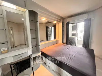 Modern bedroom with sleek design and balcony access in a stylish apartment.