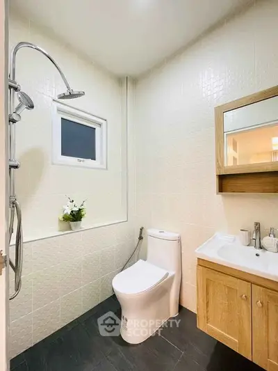 Modern bathroom with sleek fixtures and wooden vanity in a bright, minimalist design.