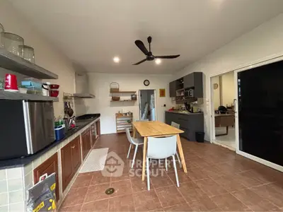 Spacious kitchen with modern appliances and dining area, featuring open layout and sleek design.