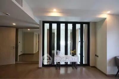 Modern interior with elegant wood flooring and stylish mirrored closet doors.