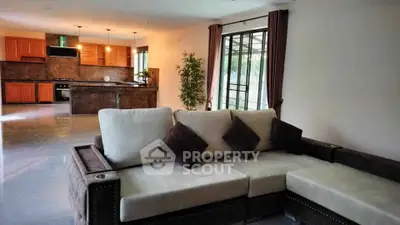 Spacious open-plan living room with modern kitchen and elegant sofa, perfect for entertaining.