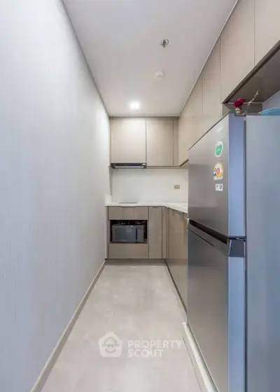 Modern compact kitchen with sleek cabinetry and stainless steel appliances