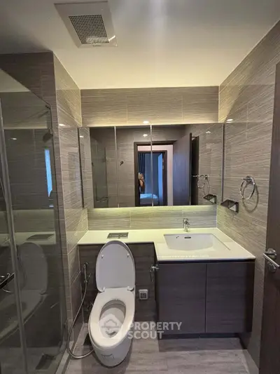 Modern bathroom with sleek design, featuring a glass shower and elegant vanity.