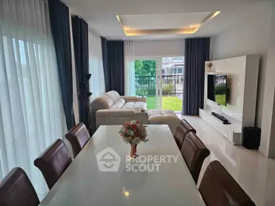 Spacious modern living room with elegant dining area and garden view, perfect for family gatherings.