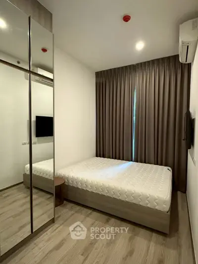 Modern minimalist bedroom with mirrored closet and natural light