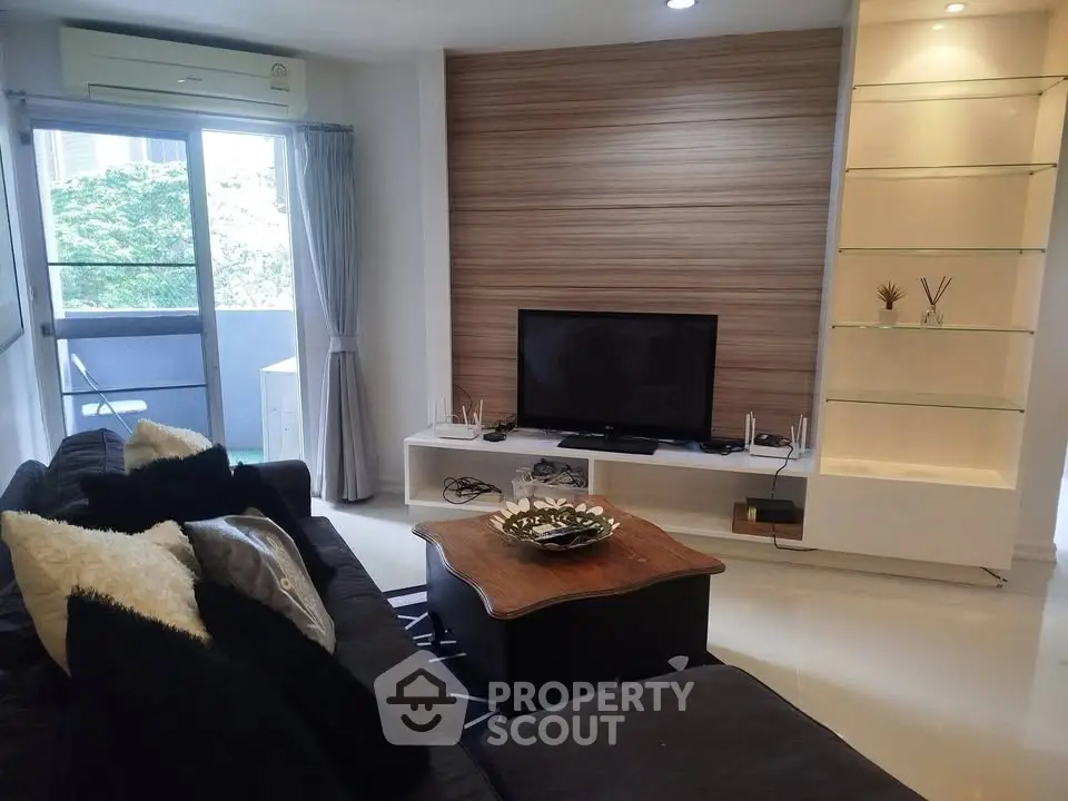 Modern living room with sleek design, featuring a cozy sofa, flat-screen TV, and elegant shelving unit.