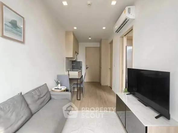 Modern living room with sleek furniture and open kitchen layout in a stylish apartment.