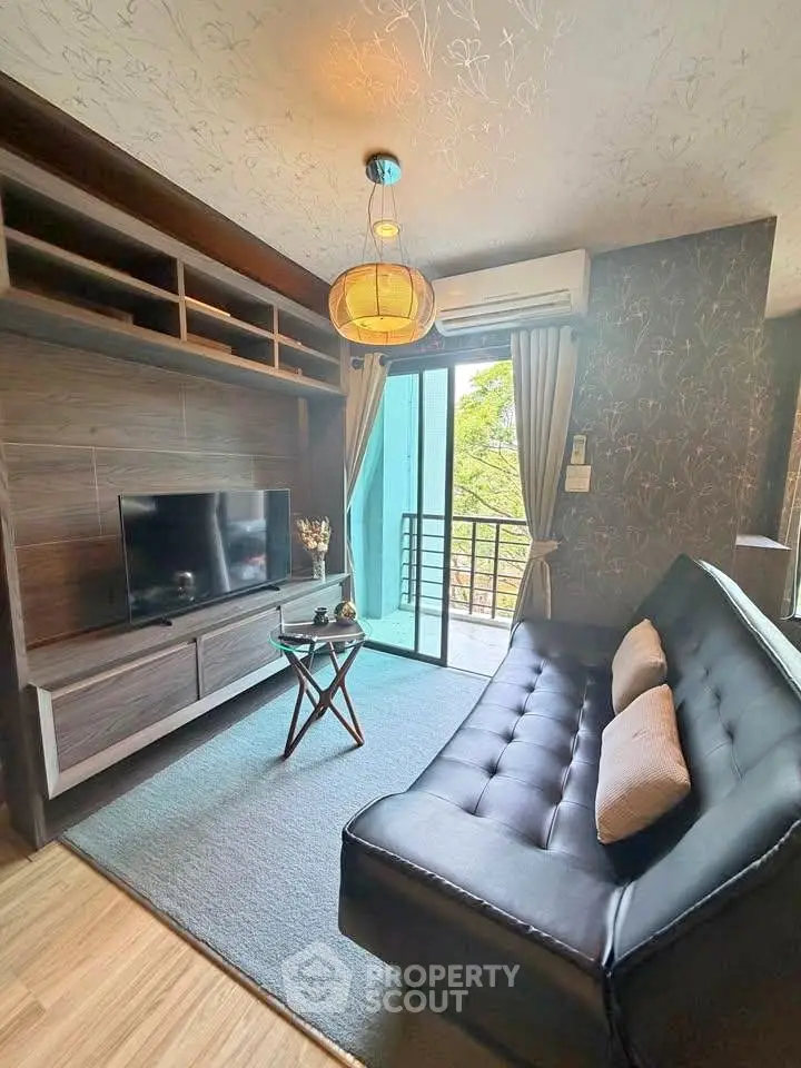 Modern living room with sleek black sofa, TV unit, and balcony access, perfect for urban living.