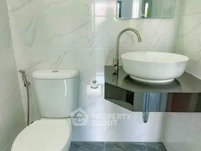 Modern bathroom with sleek fixtures and elegant corner sink design.