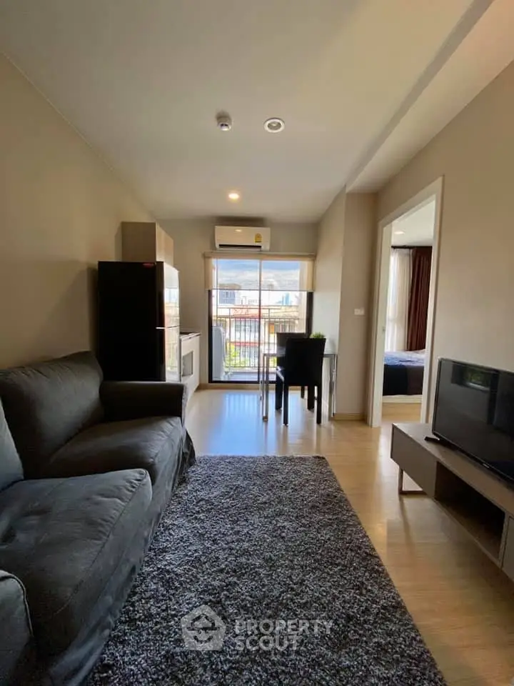 Modern living room with cozy sofa, TV, and balcony view in stylish apartment