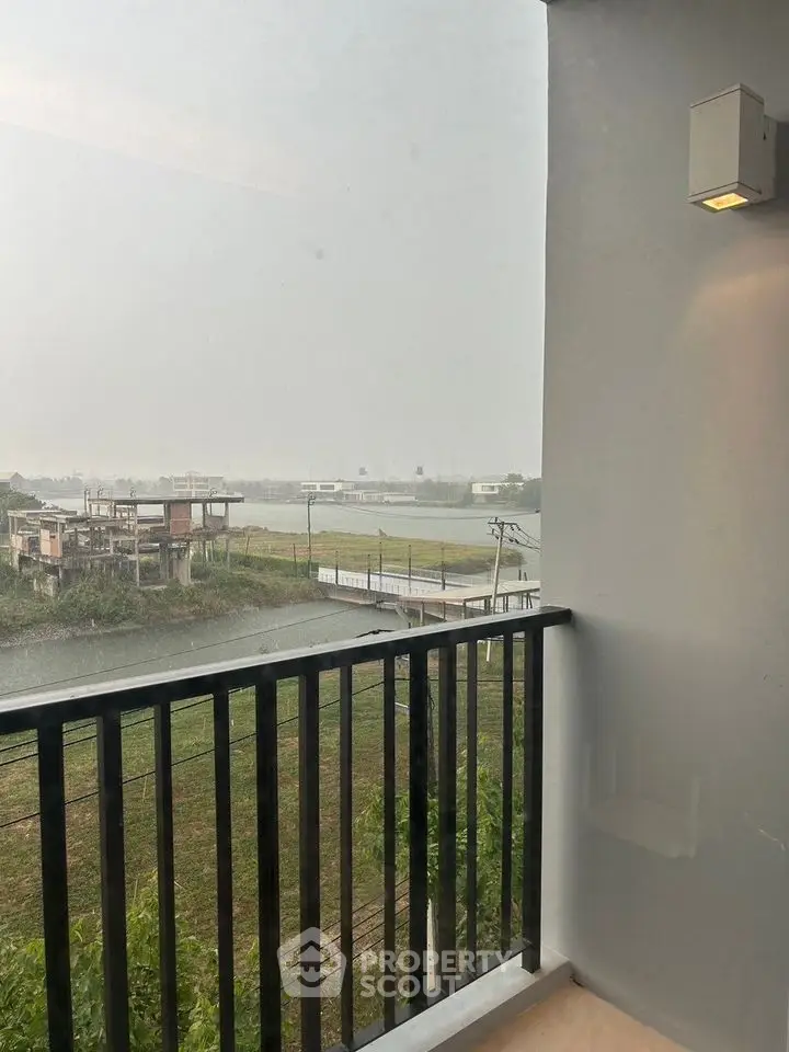 Stunning balcony view overlooking serene river and lush greenery, perfect for relaxation.