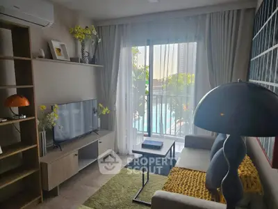 Modern living room with pool view, stylish decor, and natural light.