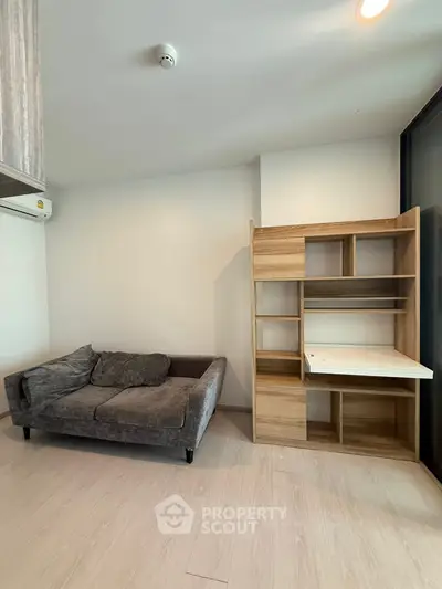 Modern living room with cozy gray sofa and stylish wooden shelving unit