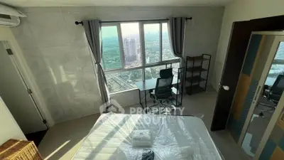 Modern bedroom with city view, featuring a large window, desk, and minimalist decor.