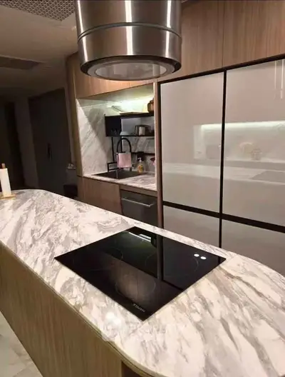 Modern kitchen with marble island and sleek appliances, perfect for culinary enthusiasts.