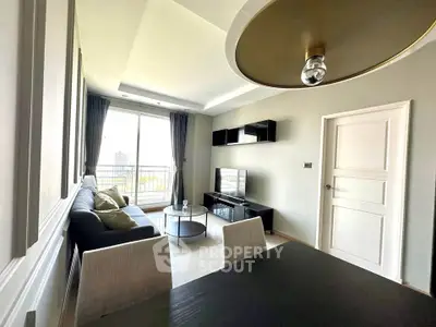 Modern living room with sleek furniture and large window offering natural light