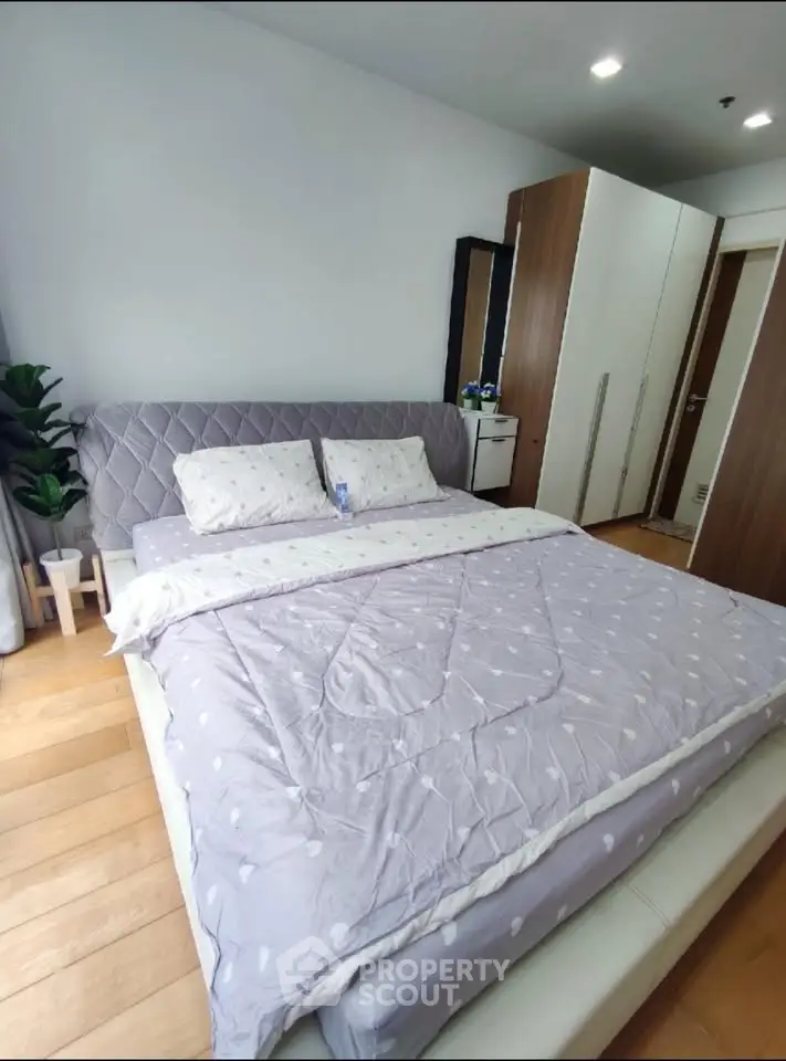 Spacious bedroom with modern decor and cozy bedding in a stylish apartment.