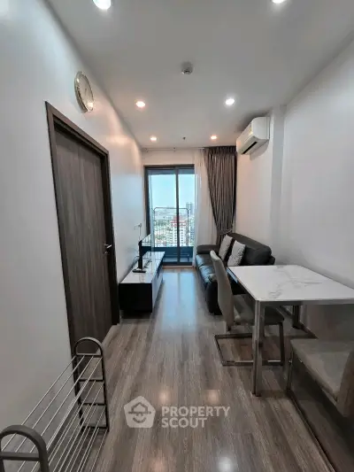 Modern living room with sleek design and balcony view in a high-rise apartment.