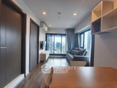 Modern living room with city view, stylish furniture, and wooden flooring.