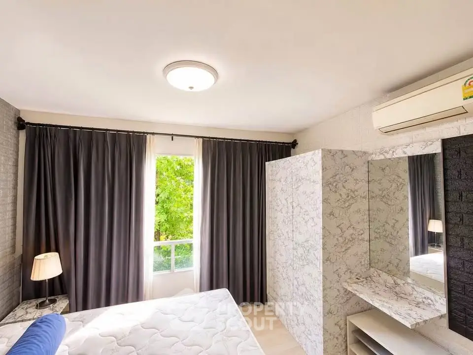Bright bedroom with large window, elegant curtains, and modern air conditioning unit.