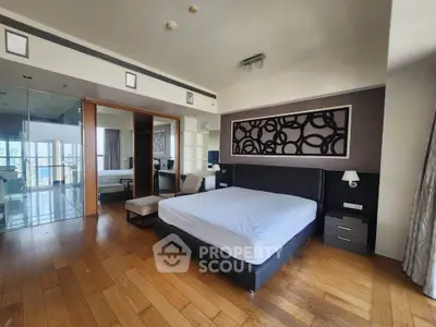 Luxurious bedroom with modern decor and wooden flooring in a high-end apartment.