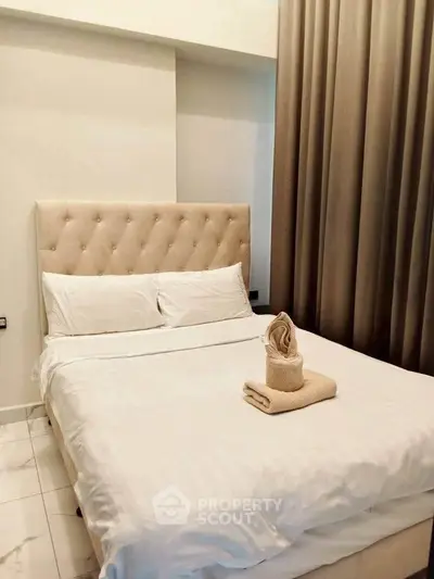 Elegant bedroom with plush headboard and luxurious linens in modern apartment.