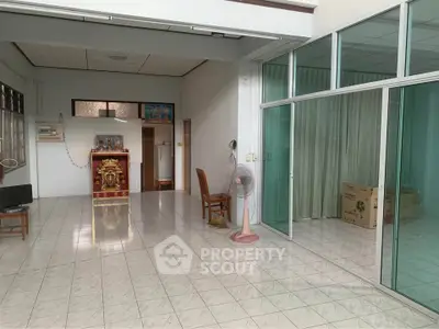 Spacious interior with tiled flooring and sliding glass doors, ideal for versatile living arrangements.