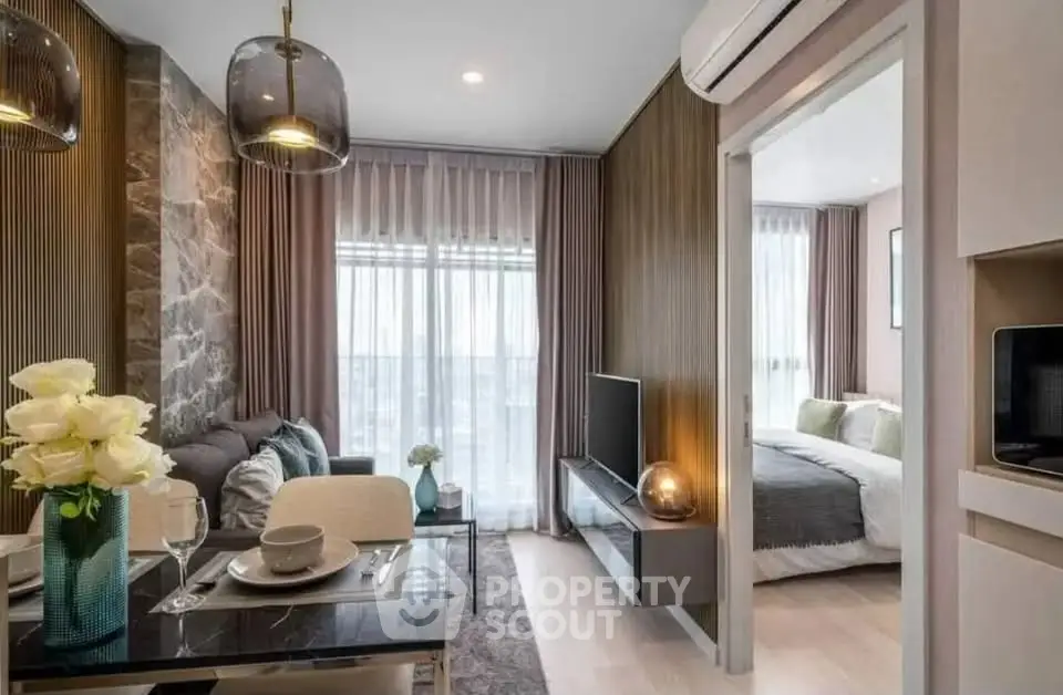 Modern open-plan living room with elegant decor and cozy bedroom view.