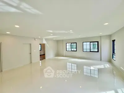 Spacious modern living room with large windows and glossy tile flooring