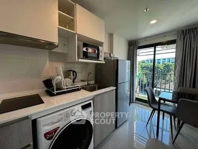 Modern kitchen with washing machine and balcony view in stylish apartment