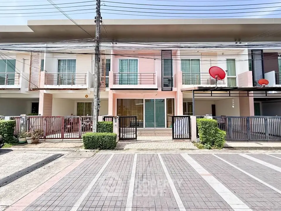 Modern townhouse exterior with parking space and vibrant facade in a suburban neighborhood.