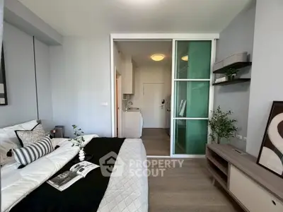 Modern bedroom with sliding glass door and stylish decor in a contemporary apartment.