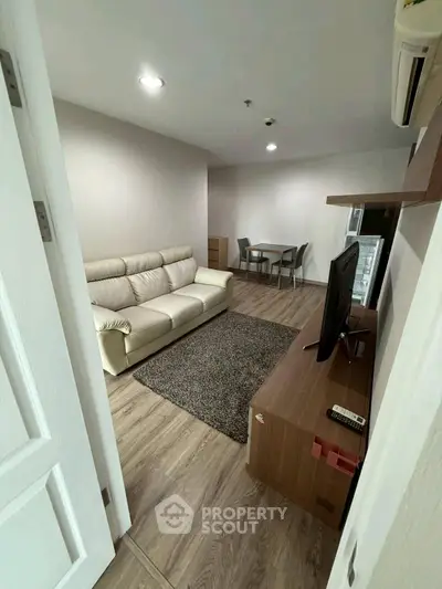 Modern living room with cozy sofa and dining area in open layout apartment.