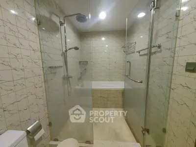 Luxurious bathroom with glass shower and elegant tile design