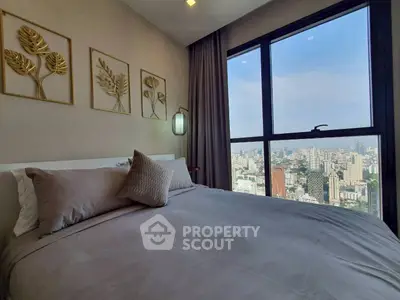 Luxurious bedroom with stunning city view from large window, elegant decor and cozy bedding.