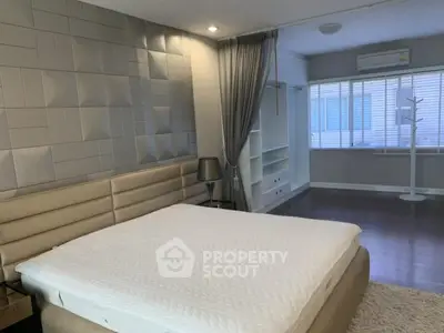 Spacious modern bedroom with stylish decor and ample natural light