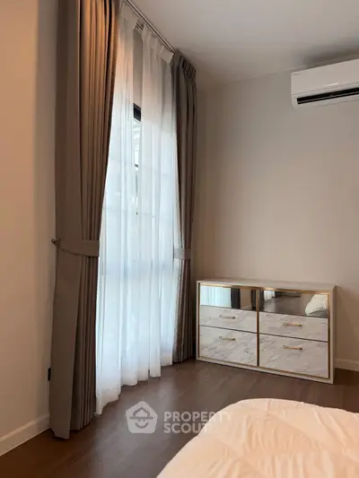 Cozy bedroom with elegant curtains and modern air conditioning unit