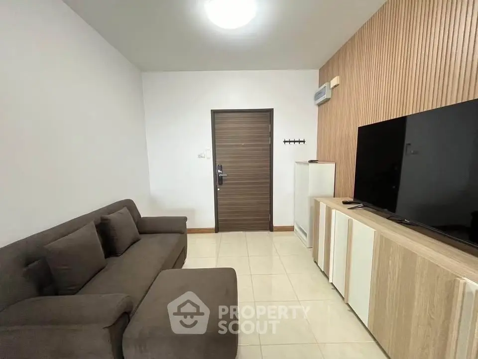 Modern living room with sleek furniture and large TV, perfect for relaxation.
