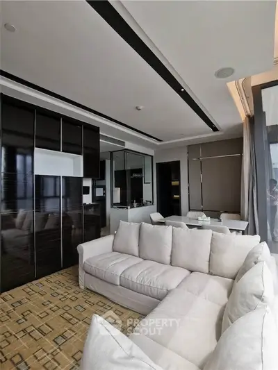 Luxurious modern living room with plush white sofa and sleek black cabinetry
