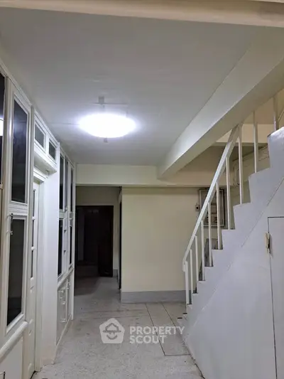 Spacious interior hallway with staircase and bright lighting