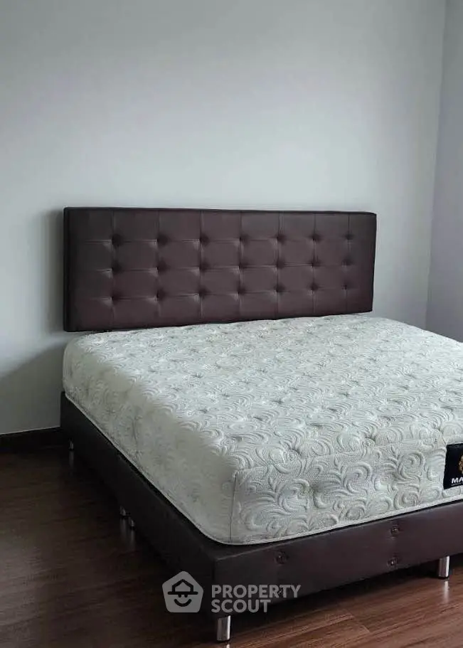 Modern bedroom with stylish bed and hardwood flooring