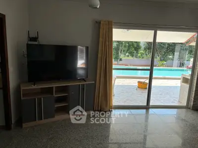 Spacious living room with pool view through sliding glass doors