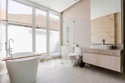 Luxurious modern bathroom with freestanding bathtub and large window for natural light.