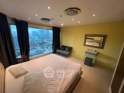 Spacious bedroom with city view, featuring modern decor and large windows for natural light.
