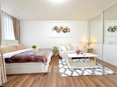 Spacious modern bedroom with cozy seating area and stylish decor