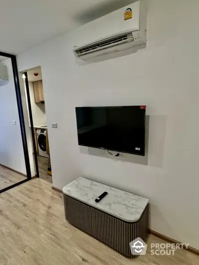 Modern living room with wall-mounted TV and air conditioning unit